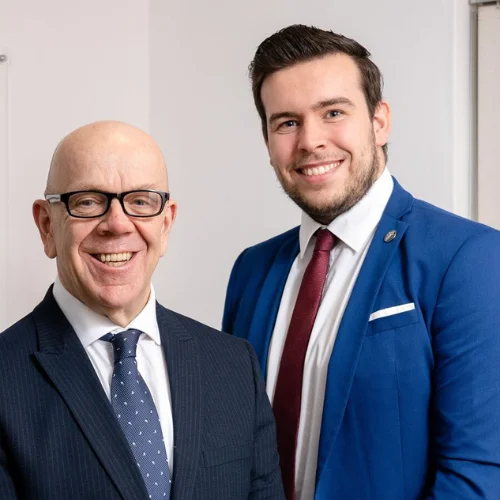 Dominic Moss and Tom, head solicitors, standing in suits, ready to assist with referral claims.